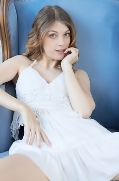 Naty Evans Seduces In Lace As She Poses Barefoot On A Blue Chair By The Window In Her White Dress